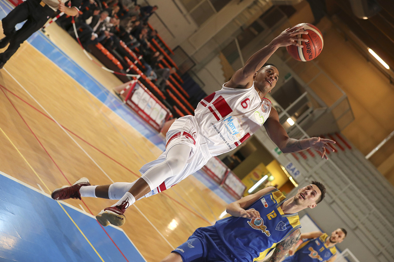 Fotografia sportiva. Un giocatore di basket mentre fa canestro durante una partita. Foto di Luca Finessi.